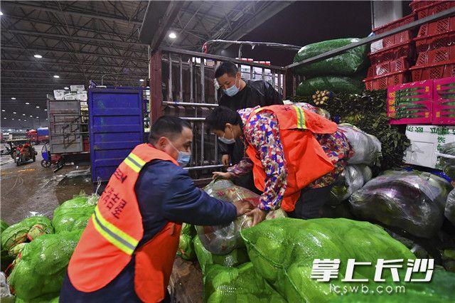 长沙黄兴海吉星国际农产品物流园内,工人们在紧张装卸蔬菜.